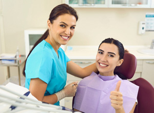 Happy dental patient making thumbs up gesture