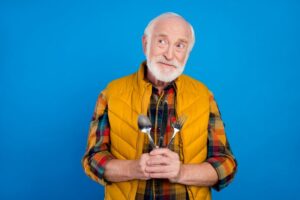 Senior man holding fork and spoon